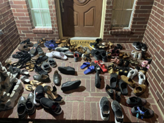 Pile of shoes removed at a doorway