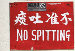 Red NO SPITTING sign in Chinese and English
